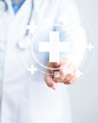 Ein Arzt in einem weißen Kittel berührt mit einem Finger ein digitales Pluszeichen, das in einem holografischen Interface dargestellt ist. Ein Stethoskop ist um seinen Hals gelegt.